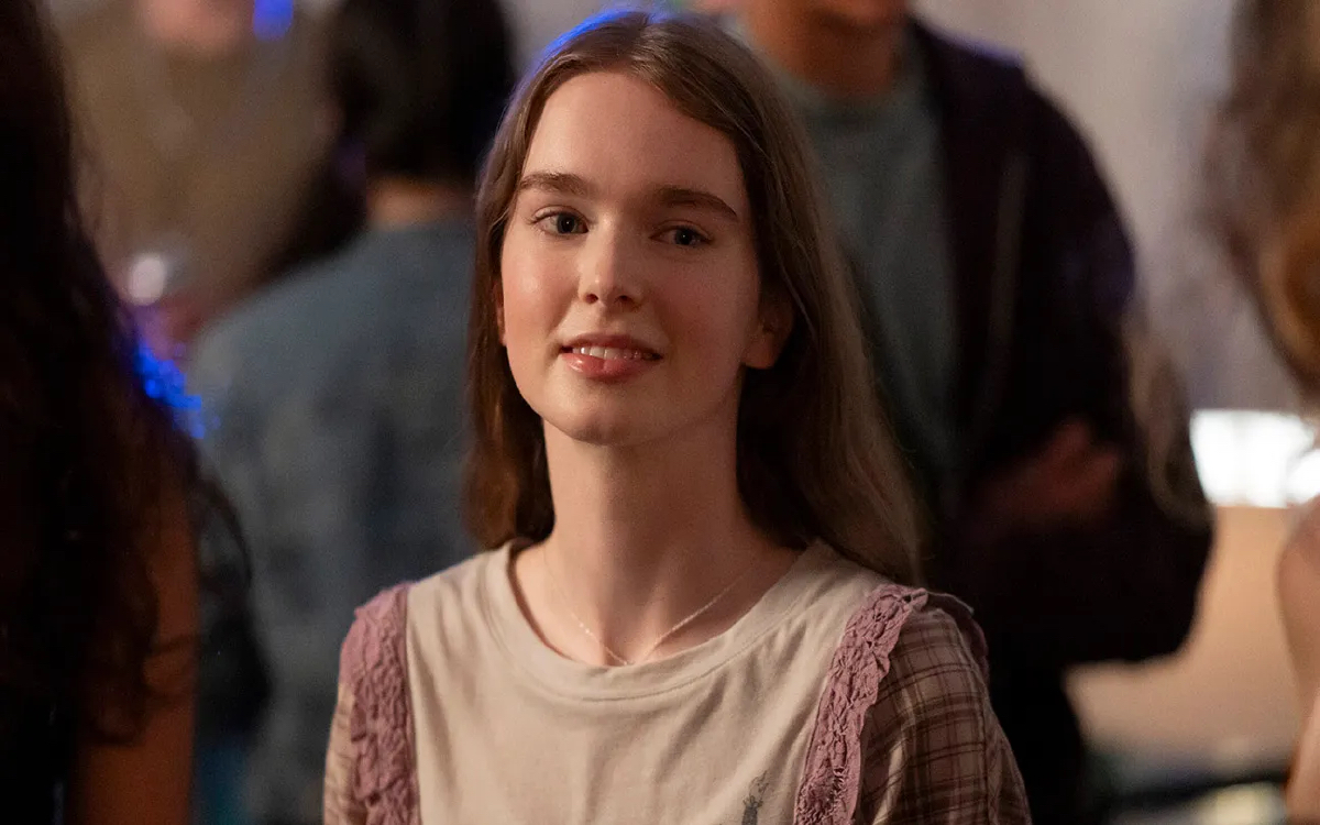 A young girl with brown hair smiling at the camera