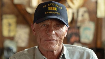 An old man with a blue cap looking at the camera.