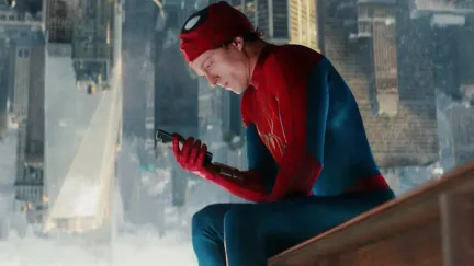 a man in a superhero costume looking at a phone