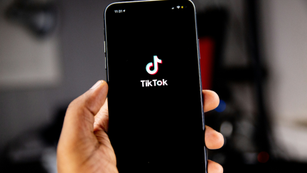 hand holding phone on the TikTok app.