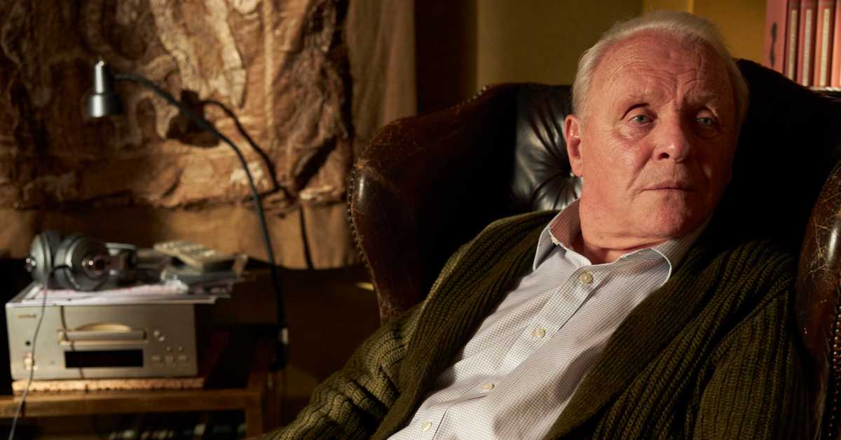 an old man in a chair looking at something off camera