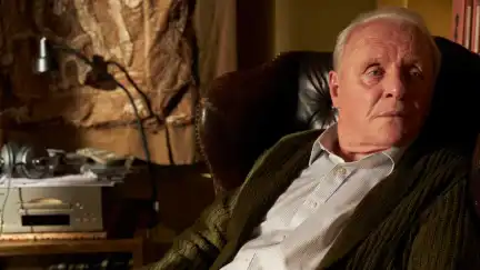 an old man in a chair looking at something off camera