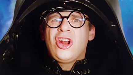 A man with glasses pulls a funny face wearing a huge helmet