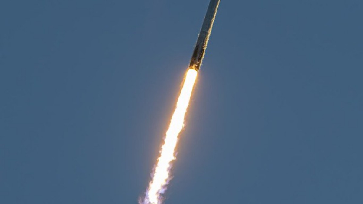 A SpaceX Falcon 9 launches into space with fire trailing it.