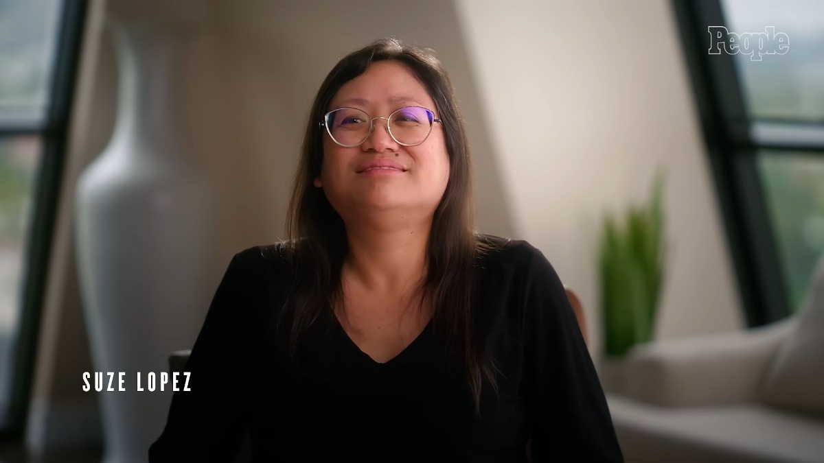 A photo of a woman facing a camera for an interview in a plain room