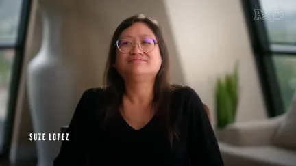 A photo of a woman facing a camera for an interview in a plain room