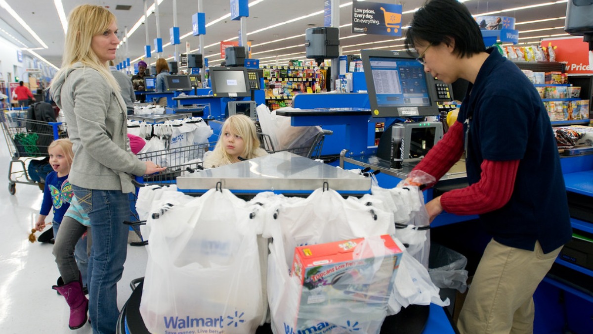 Worker bags up a grocery purchase in store.