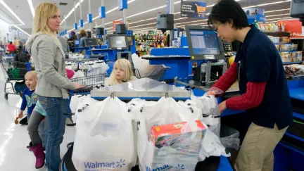 Worker bags up a grocery purchase in store.