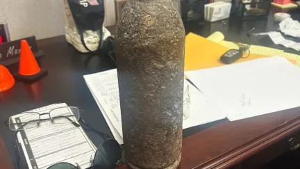 An artillery shell from the Civil War sits on a messy desk