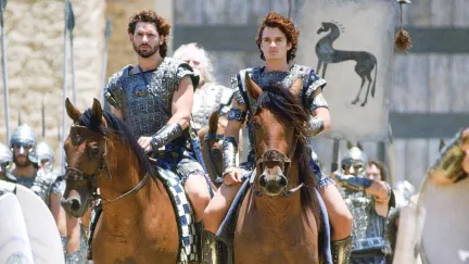 Actors Eric Bana and Orlando Bloom in the movie Troy (2004) horse-riding in warrior costumes.